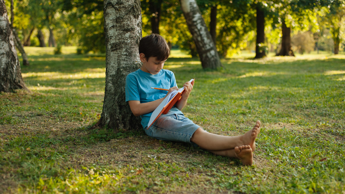 Child writing in a journal outdoors in a quiet flexible learning space