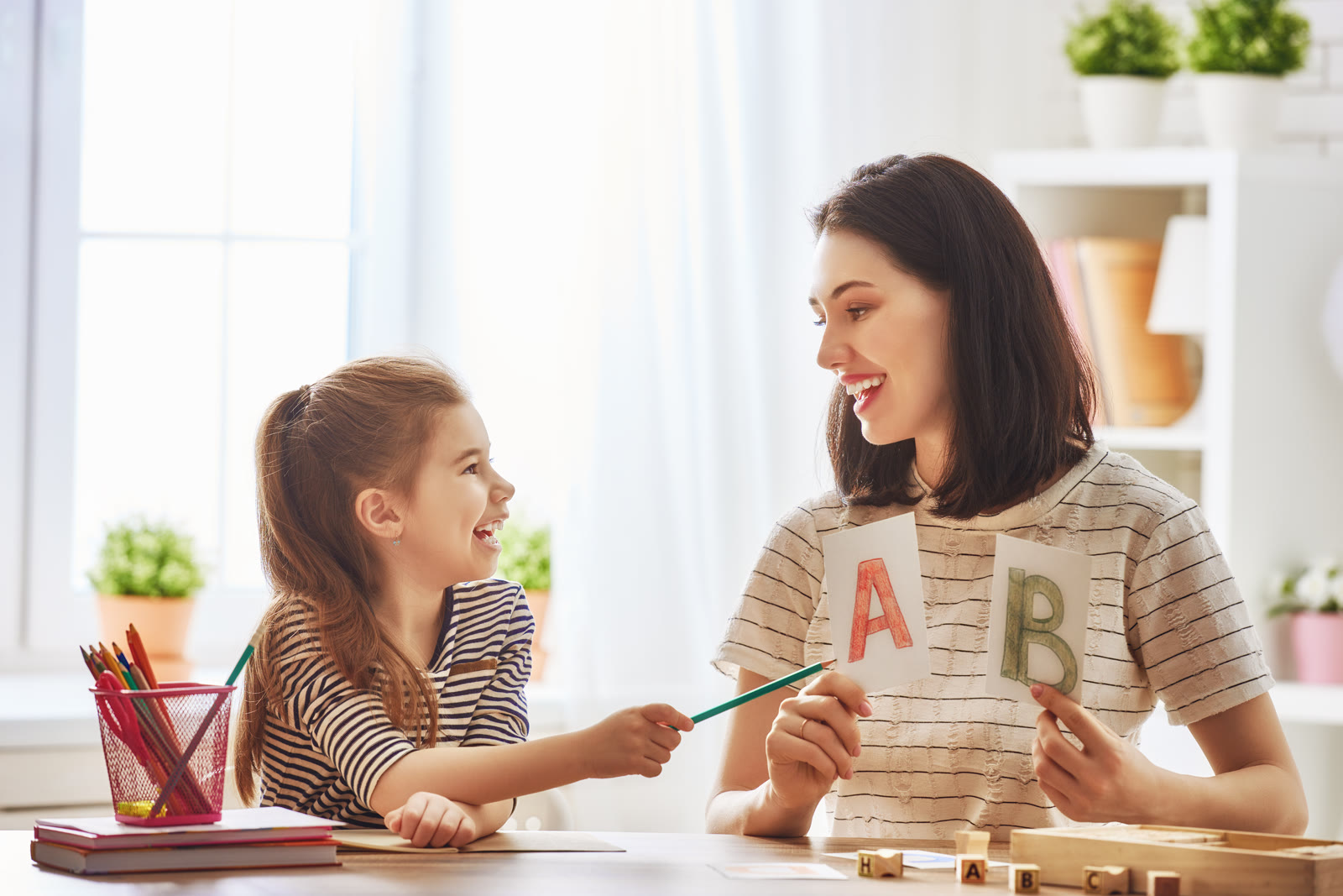 Parent helping a child practice an early learning activity at home